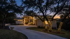 Professional Christmas light installation on a wooded hillside home in West Lake Hills, TX
