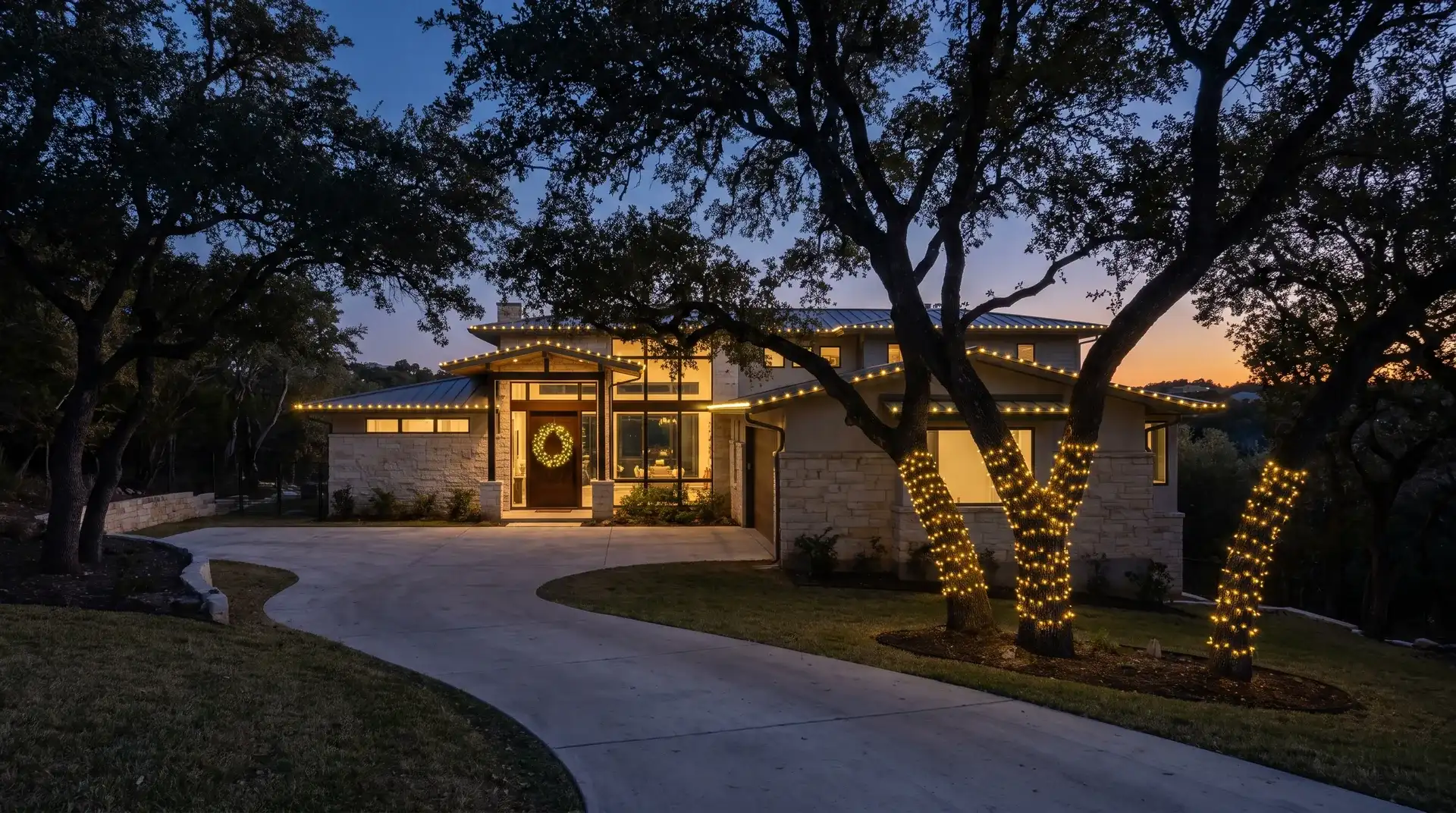 Professional Christmas light installation on a wooded hillside home in West Lake Hills, TX