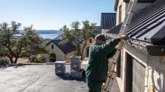 Installer taking down Christmas lights from a Lake Travis hillside estate in Lakeway, TX for labeled storage