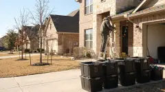 Installer taking down Christmas lights from a two-story brick home in Round Rock, TX for labeled storage