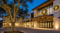 Commercial holiday lighting with wrapped trees and lit wreaths at a home in Austin, Texas