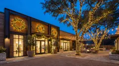 Commercial holiday lighting with wrapped trees and lit wreaths at a business in Austin, TX