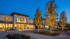 Commercial holiday lighting with wrapped trees and lit wreaths at a business in Pflugerville, TX