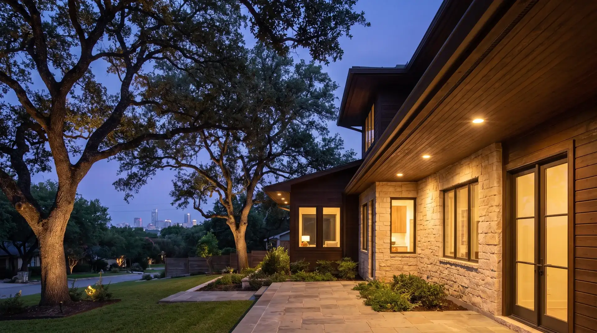 Permanent LED Christmas lights hidden under the eaves of a craftsman home under live oaks in Austin, TX