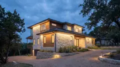 Permanent LED Christmas lights hidden under the eaves of a limestone Hill Country home in Cedar Park, TX