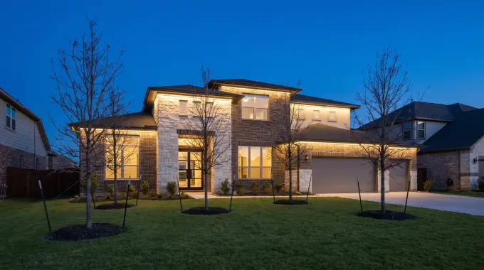 Permanent LED Christmas lights hidden under the eaves of a two-story brick home in Round Rock, TX