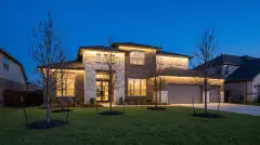 Permanent LED Christmas lights hidden under the eaves of a two-story brick home in Round Rock, TX