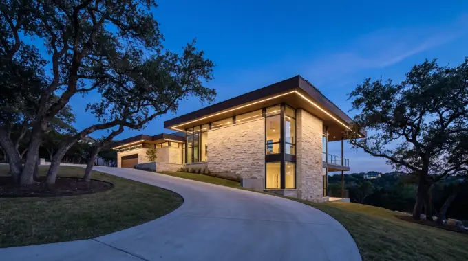 Permanent LED Christmas lights hidden under the eaves of a wooded hillside home in West Lake Hills, TX