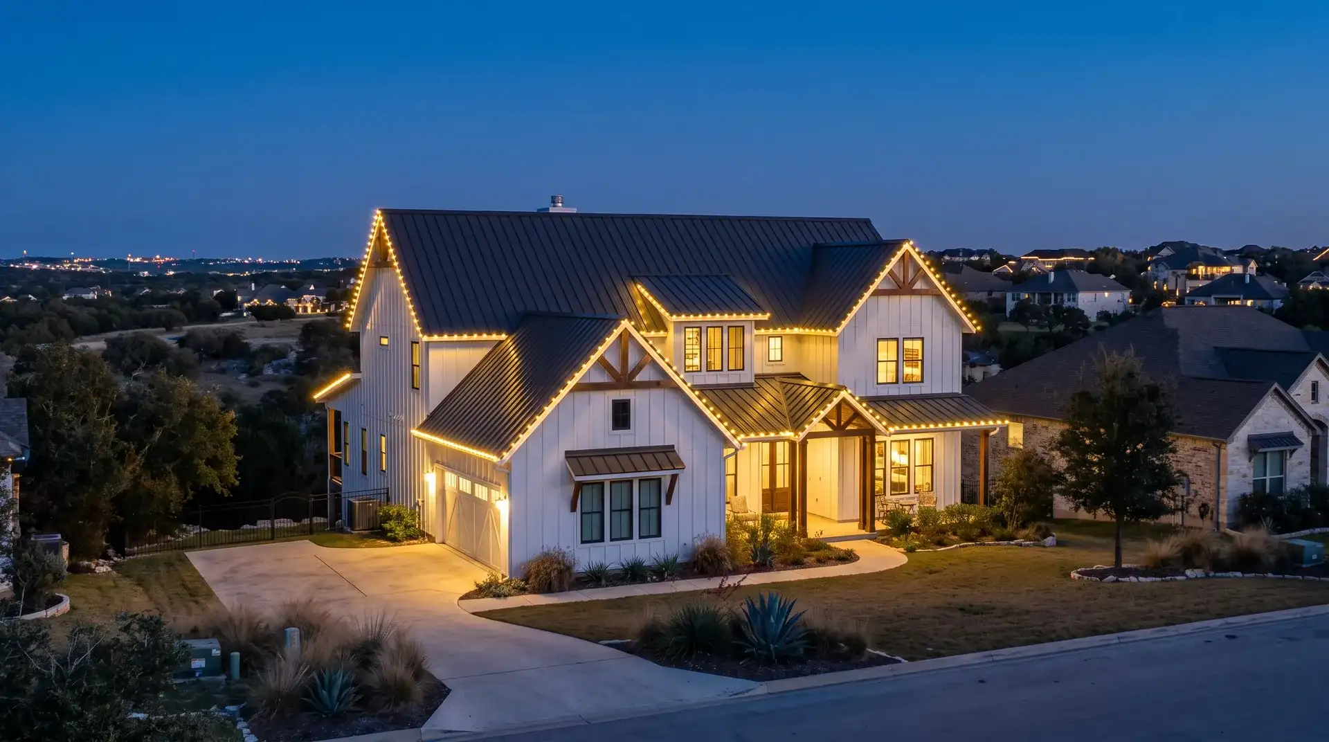 Custom-fit warm-white C9 Christmas lights outlining the roofline of a modern farmhouse home in Leander, TX