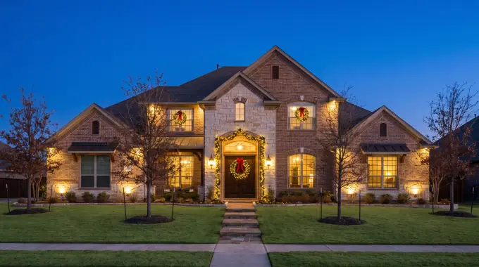 Pre-lit wreath and garland installed on the front entry of a two-story brick home in Round Rock, TX